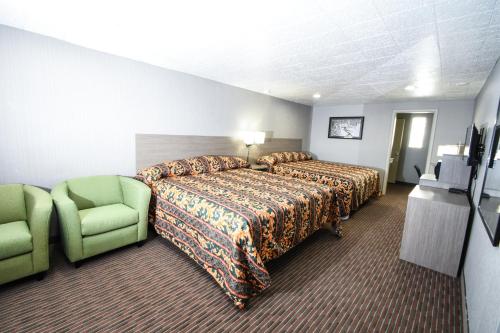 a hotel room with a bed and a green chair at Belcaro Motel in Denver