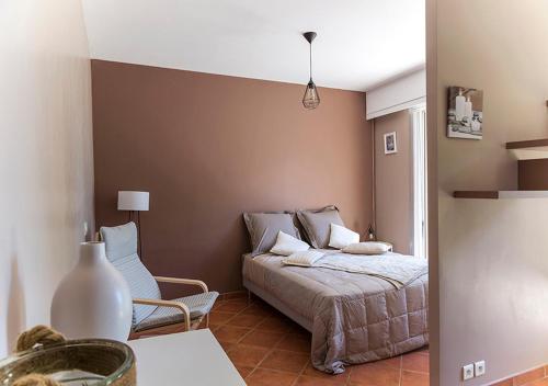 a bedroom with a bed and a chair at Au Coeur des Vignes en Provence in Châteauneuf-de-Gadagne