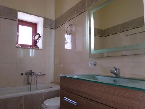a bathroom with a sink and a tub and a toilet at Kasteli House in Spetses