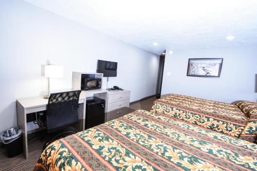 a hotel room with a bed and a television at Belcaro Motel in Denver