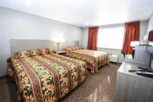 een hotelkamer met 2 bedden en een televisie bij Belcaro Motel in Denver