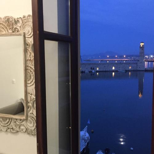 a window with a view of a body of water at Porto Enetiko Suites in Rethymno Town