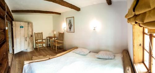 a bedroom with a bed with two pillows on it at Dzikie Roztocze - Stara Chata in Krasnobród