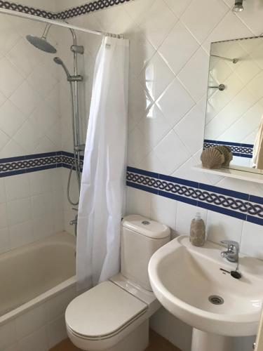 y baño con aseo, lavabo y espejo. en Beautiful penthouse with ocean and marina views, en Isla Canela