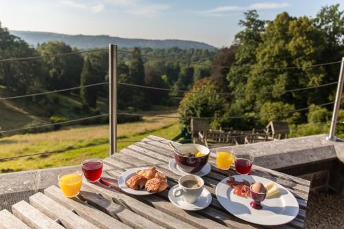 una mesa con platos de comida y vasos de jugo de naranja en Domaine de Ronchinne - Maison du Jardinier, en Maillen