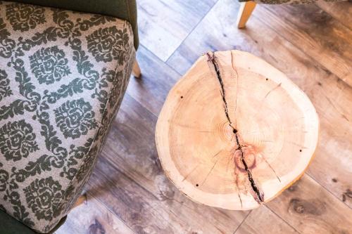 a wooden stump sitting on the floor next to a chair at Hotel Garden in Moena