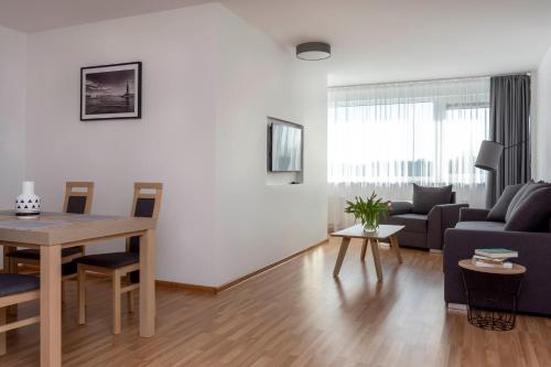 a living room with a table and a couch at Apartment Amber Wind in Palanga
