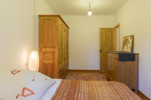 a bedroom with a bed and a dresser in it at Cal Menescal in Les Olives