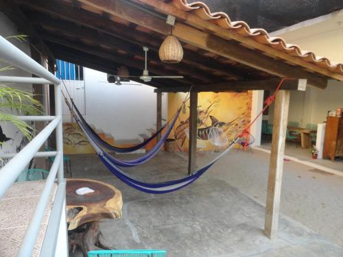 a room with a wooden floor and a fence at Paziflora Hostel in Puerto Escondido