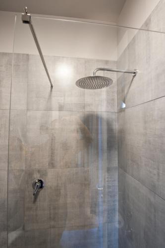 a shower with a glass door with a shower head at Relais Lo Stagnone in Marsala
