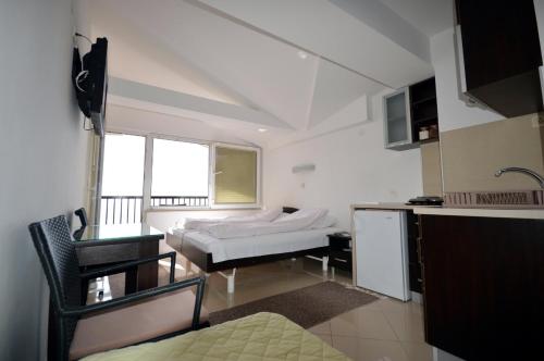 Zimmer mit einem Bett, einem Schreibtisch und einer Küche in der Unterkunft Topencarov Guest House in Ohrid