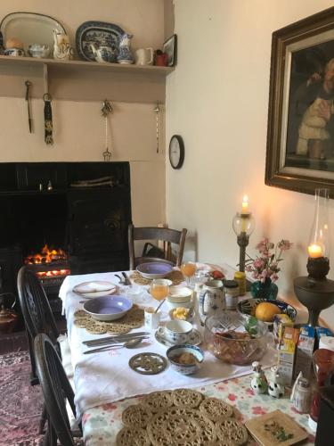a dining room table with food on it with a fireplace at Church Street Homestay in Beaumaris