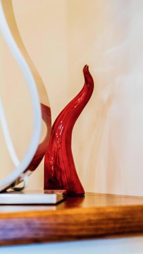 a red glass vase sitting on a wooden table at Villa Cua in Ercolano