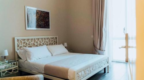a bedroom with a white bed with a picture on the wall at Villa Cua in Ercolano