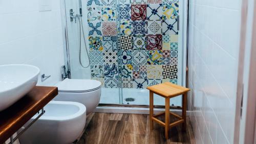 a bathroom with a shower and a toilet and a stool at Villa Cua in Ercolano