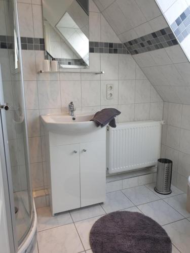 a bathroom with a sink and a shower at Hus-Annett-Lüchttoorm in Tating