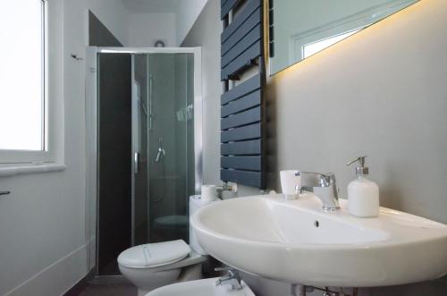 a white bathroom with a sink and a toilet at Villa Zagara Garden Spectacular Sea View in Taormina in Taormina
