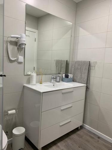 a white bathroom with a sink and a mirror at Starhouse in Lisbon