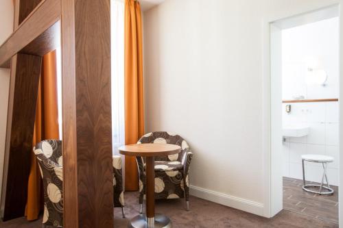 a small table and chairs in a room with a window at Hotel Villa Auguste Viktoria in Ahlbeck