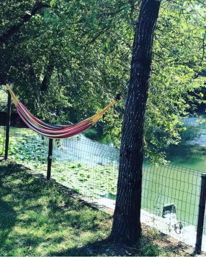 a hammock tied to a tree next to a fence at Wooden Village Resort in Ponari