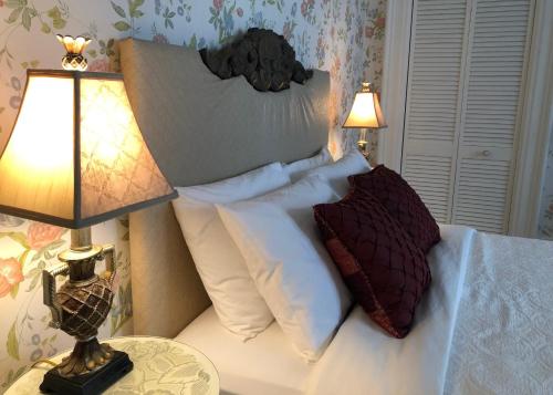 a bedroom with a bed with pillows and two lamps at Balmoral House Bed & Breakfast in St. John's