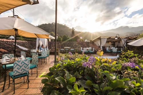 een patio met tafels, stoelen en bloemen bij Hotel Boutique Los Pasos & Spa in Antigua Guatemala
