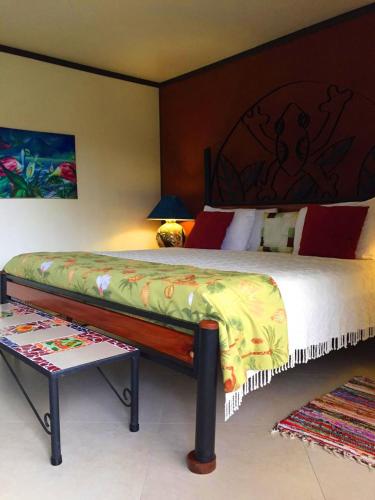 a bedroom with a large bed and a table at Lucky Bug Bed And Breakfast in Nuevo Arenal