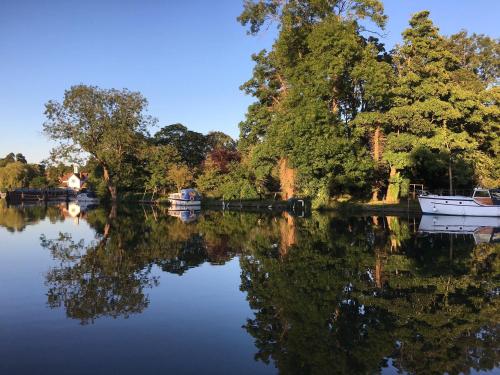 a scenic view of a park with a river and trees at The Swan at Streatley in Streatley