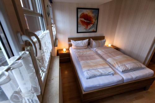 ein kleines Schlafzimmer mit einem Bett und zwei Lampen in der Unterkunft Haus Pop in Borkum