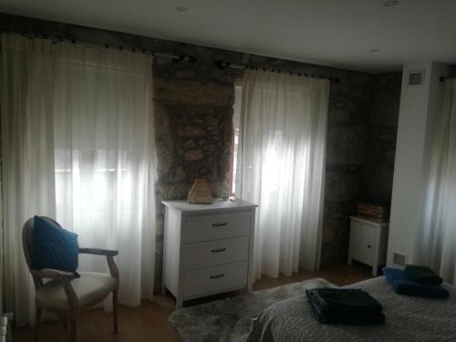 a bedroom with a bed and a chair and a dresser at Isabel do Couto - casa de charme in Castro Daire