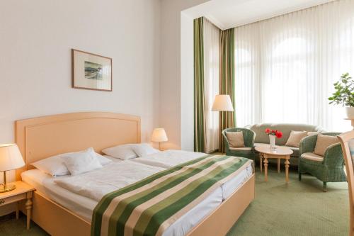 a bedroom with a bed and a living room at Hotel Villa Auguste Viktoria in Ahlbeck