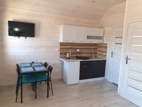 a kitchen with a table and a small table and chairs at Błękitna Laguna in Rusinowo