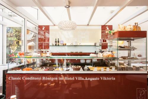 a bakery with a glass counter with food on it at Hotel Villa Auguste Viktoria in Ahlbeck