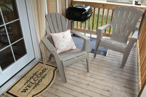 two chairs on a porch with a pillow and a grill at The Cabins at Beaver Creek in Beaver
