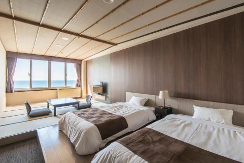 
a hotel room with two beds and a window at Imagine Hotel & Resort in Hakodate
