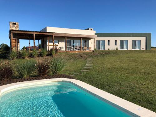a house with a swimming pool in front of a house at Carmelo Golf in Carmelo