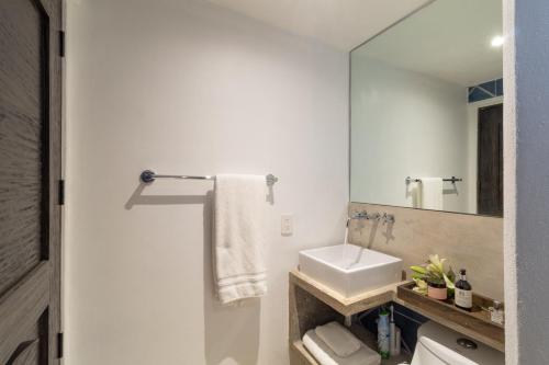 a bathroom with a sink and a mirror at Cuale in Puerto Vallarta
