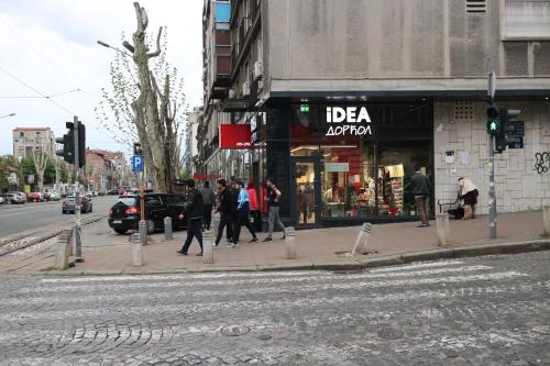 un gruppo di persone che camminano su un marciapiede di fronte a un negozio di Atelier 22 a Belgrado
