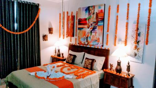 a bedroom with a bed with an orange comforter at Cantik Villa in Lovina