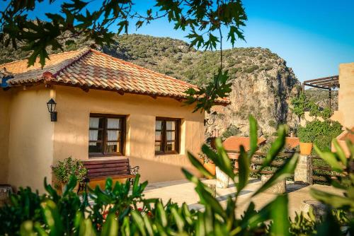 a small house with a mountain in the background at Enagron Ecotourism Village in Axós