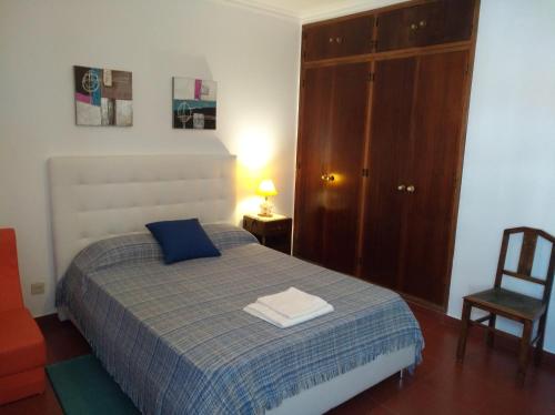 オリョンにあるVilla Formosaのベッドルーム1室(青い毛布と椅子付きのベッド1台付)