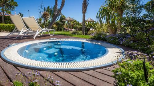 uma piscina com duas cadeiras num quintal em Mareta View - Boutique Bed & Breakfast em Sagres