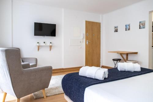een hotelkamer met een bed en een stoel bij Belém - Fully equiped Studio in Lissabon