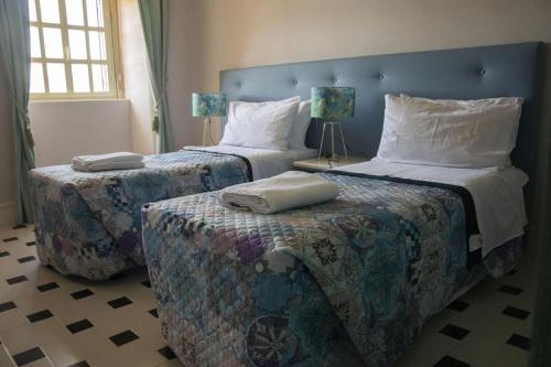 duas camas num quarto com dois repousa-pés em Villa Laura em Savoca