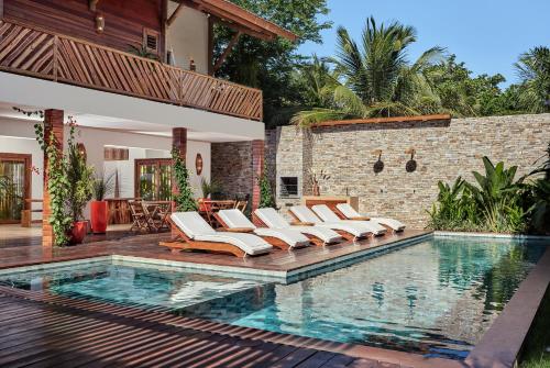 a pool with lounge chairs next to a house at VillaMag in Jericoacoara