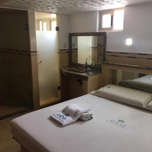 - une chambre avec un lit, des serviettes et un lavabo dans l'établissement Hotel & suites elba, à Toluca