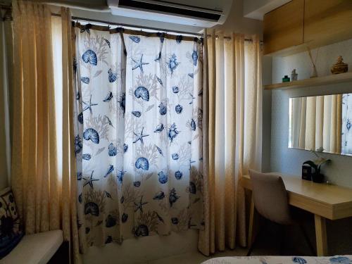 a curtain in a room with a table and a desk at Shell Residence Manila in Manila