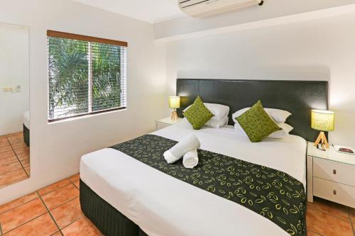 a bedroom with a large bed and a window at Paradise On The Beach Resort in Palm Cove