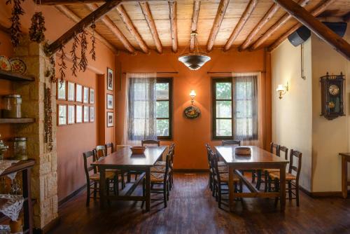 a dining room with two wooden tables and chairs at Enagron Ecotourism Village in Axós