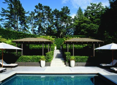 a swimming pool with two umbrellas and a swimming pool at Huka Lodge in Taupo